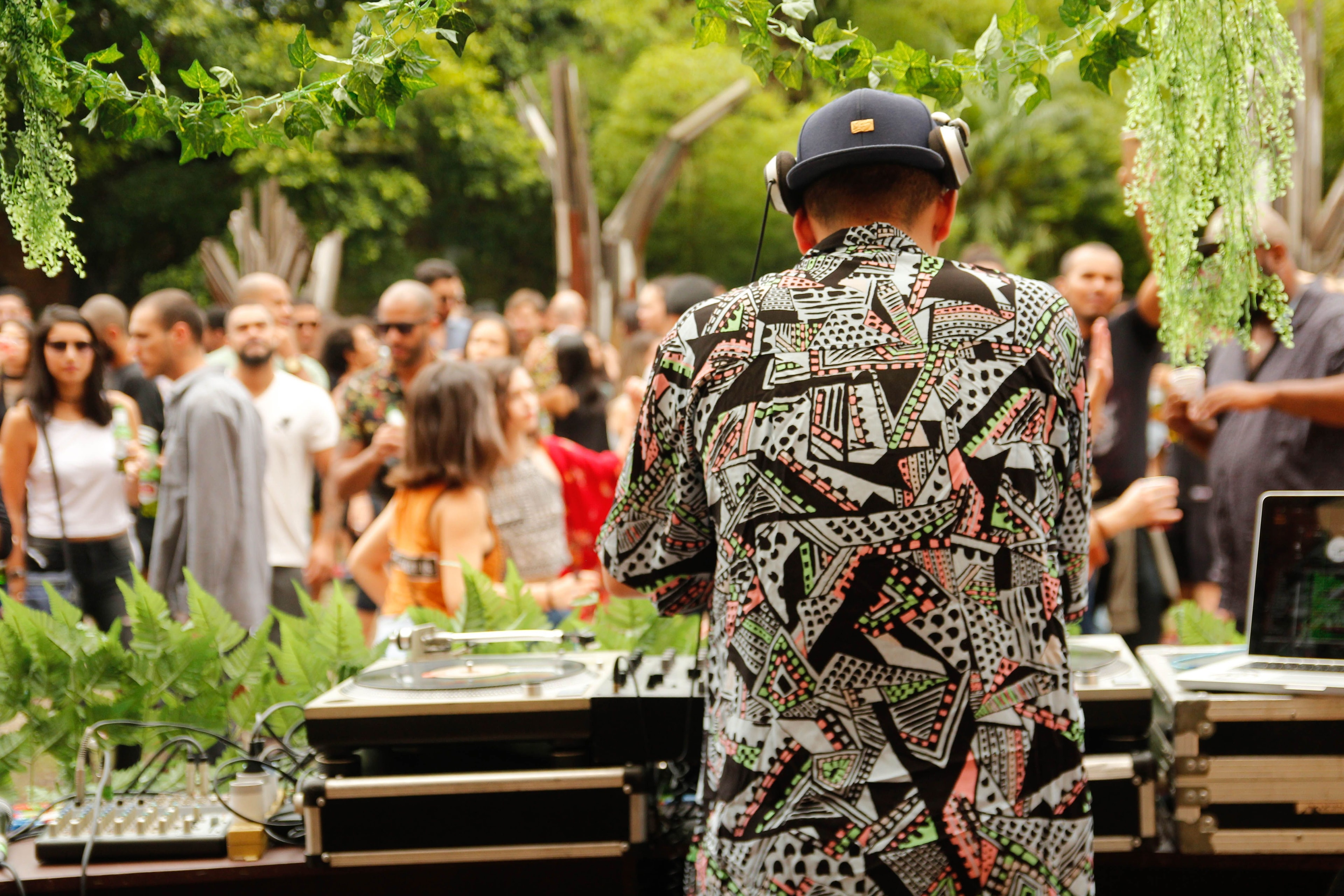 A dance floor in daylight, full of people, seen from behind the decks